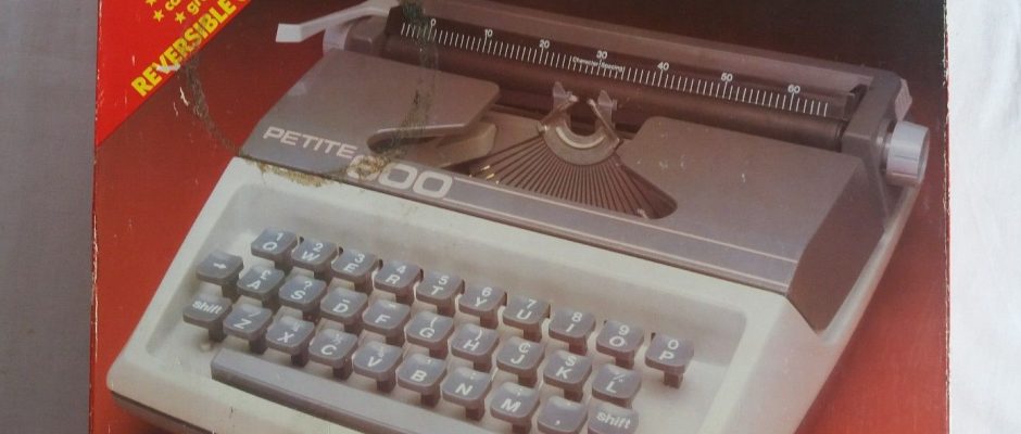 Una scatola di cartone con la fotografia di una macchina da scrivere di plastica per bambini e la scritta "petite 600"