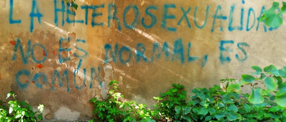 Una scritta sul muro in spagnolo che dice: l'eterosessualità non è normale, è comune