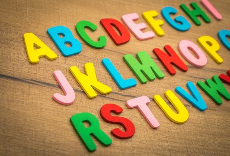 l'alfabeto scritto a lettere di plastica colorata appoggiate in tre file su una tavola di legno