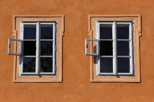 due finestre, una accanto all'altra, esattamente uguali su una parete arancione
