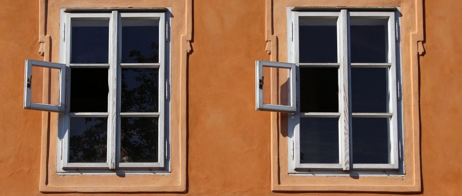 due finestre, una accanto all'altra, esattamente uguali su una parete arancione