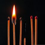 6 fiammiferi su sfondo nero, di cui 3 completamente bruciati e uno acceso