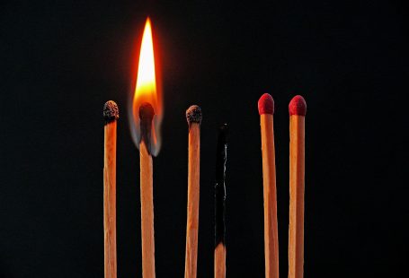 6 fiammiferi su sfondo nero, di cui 3 completamente bruciati e uno acceso