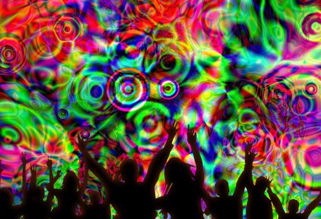 Delle silhouette di persone che ballano su uno sfondo di colori psichedelici