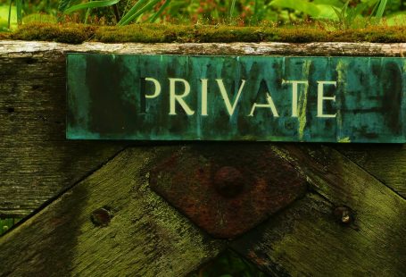 Un cartello di legno dipinto di verde attaccato su una staccionata con su scritto "private"